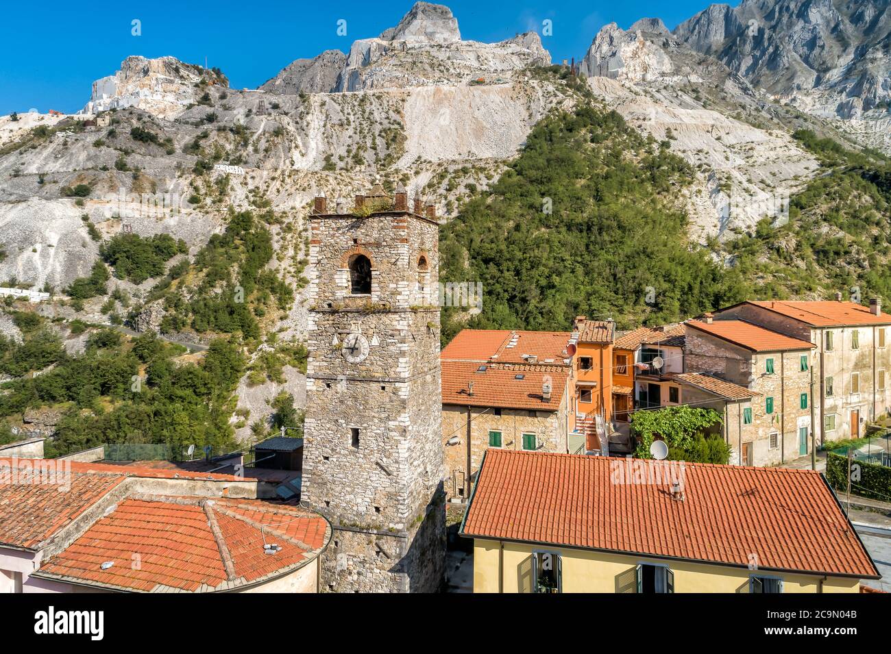 Vue aérienne du clocher de l'église Sant Bartolomeo dans l'ancien village de Colonnata et des Alpes Apuanes avec des carrières de marbre, Toscane, Italie Banque D'Images
