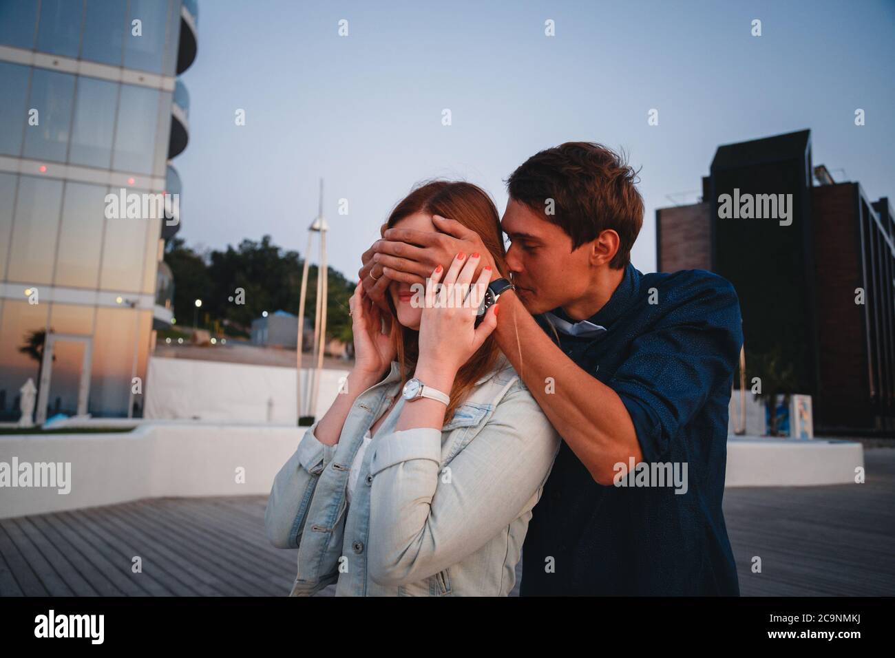 Moment surprise. Le jeune petit ami couvre les yeux de sa femme en faisant une surprise. Concept d'amour et de cadeau. Couple ensergeant à la plage en été Banque D'Images