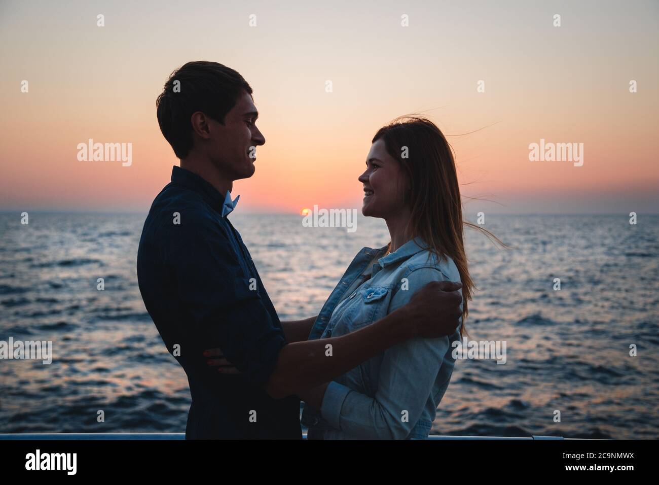 Gros plan de couple regardant le lever du soleil à la plage heure d'été, plage d'été de bord de mer à horizon de soirée bleu jaune, fond de coucher de soleil Banque D'Images