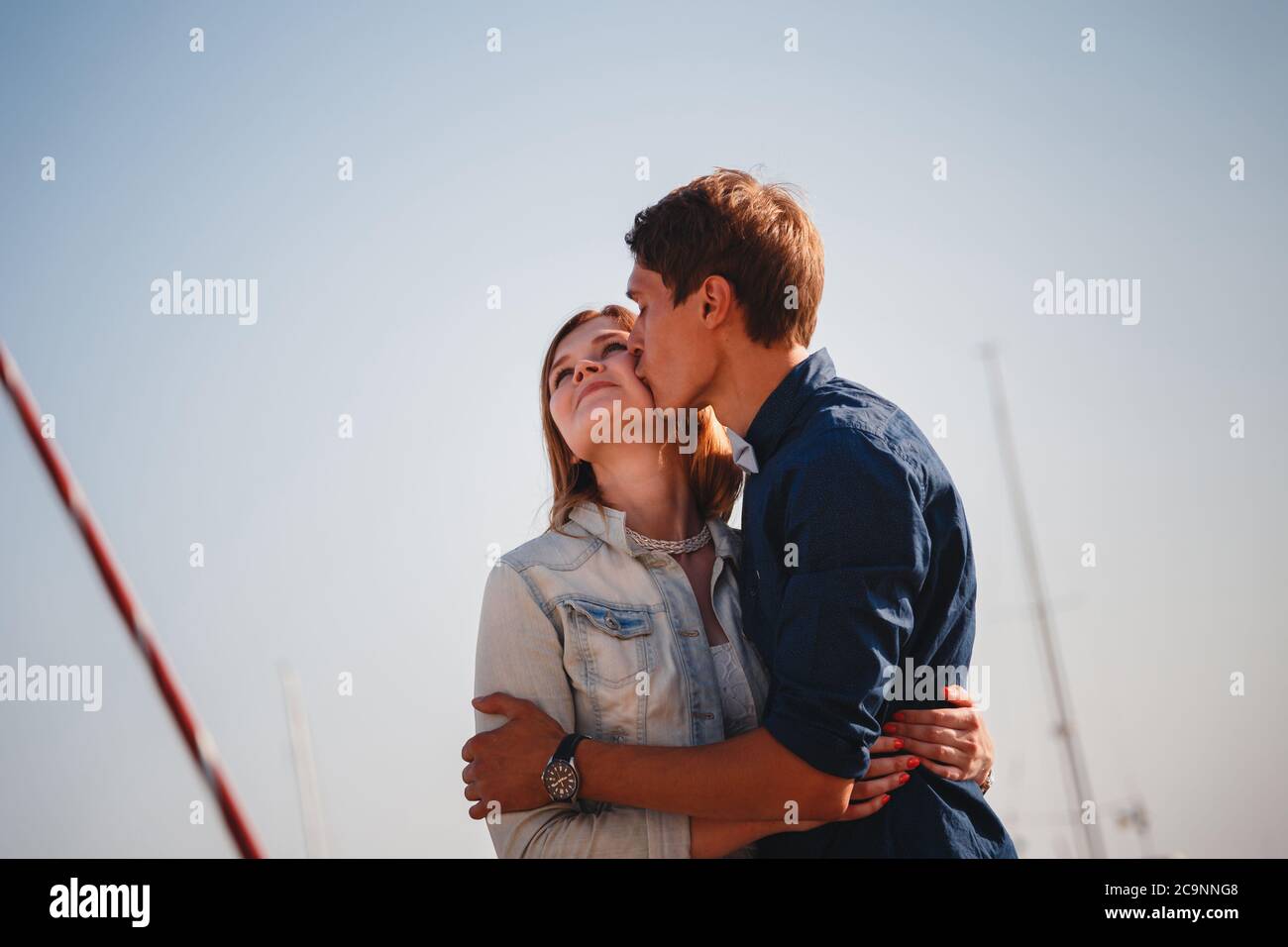 Mignon jeune beau couple à la jetée au port avec de petits yachts, hipster, heureux sourire portrait extérieur Banque D'Images