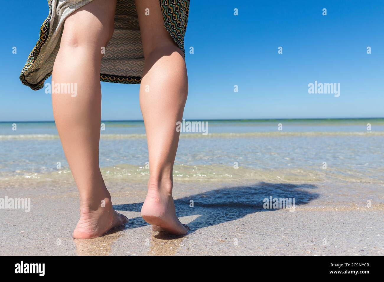 Gros plan des jambes d'une femme sur la mer. Vue au niveau du sol. Banque D'Images