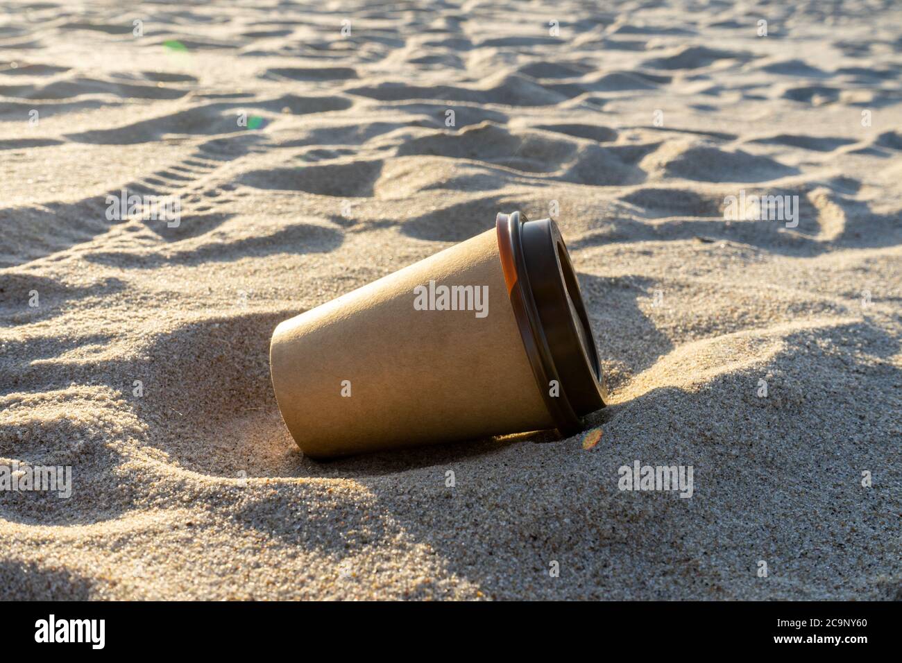 Tasse à café jetable sur la plage. Protection de la nature et concept de pollution. Banque D'Images