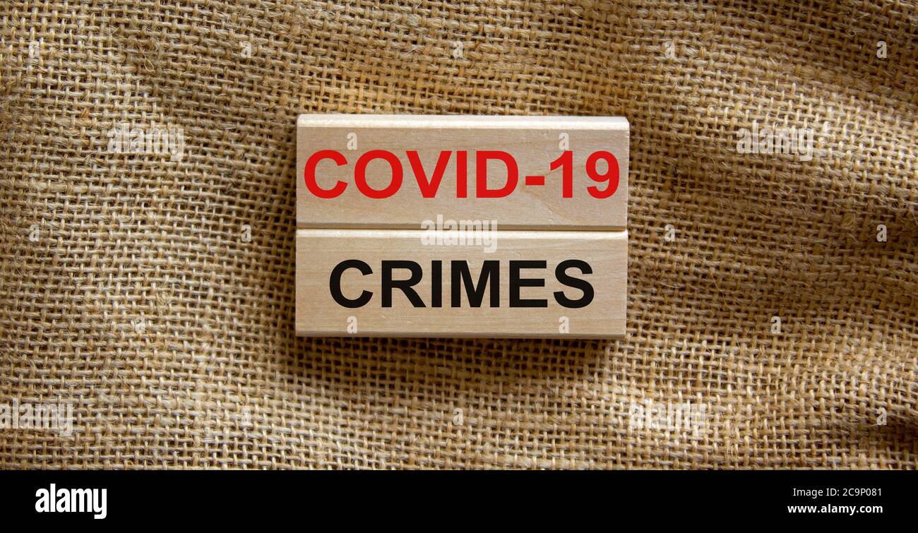 Mots « Covid-19 crimes » sur des blocs de bois. Concept d'entreprise. Magnifique arrière-plan en toile. Banque D'Images