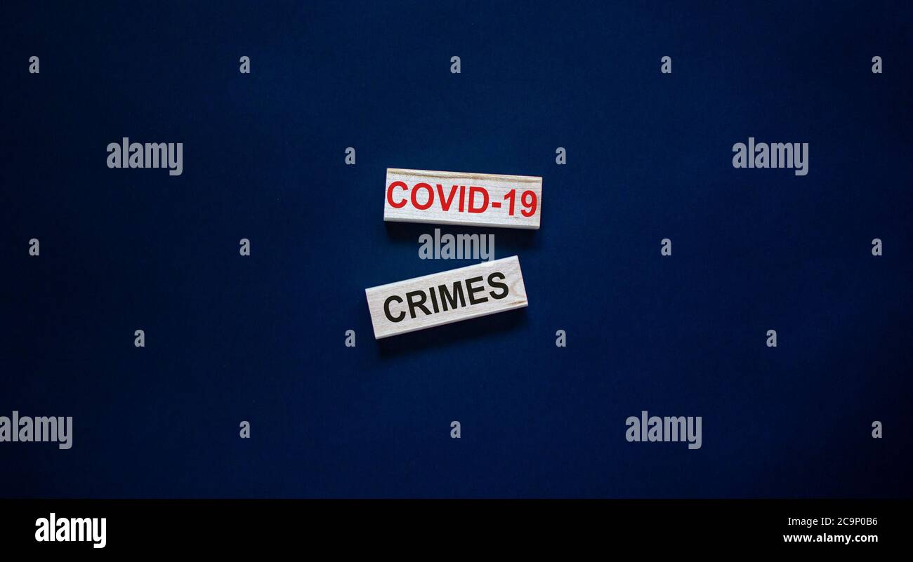 Mots « Covid-19 crimes » sur des blocs de bois. Concept d'entreprise. Magnifique arrière-plan noir. Banque D'Images