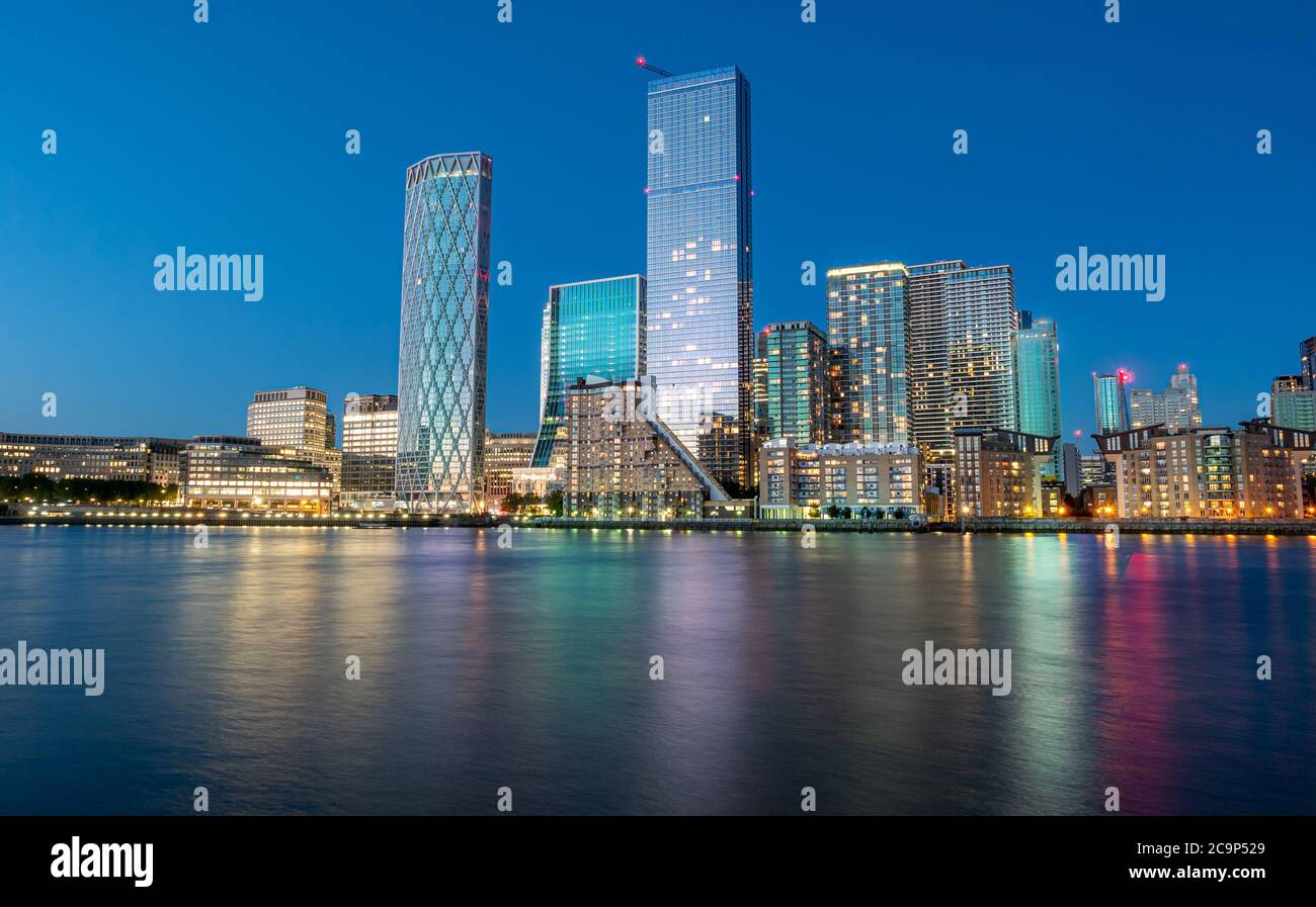 Le quartier financier de la ville de Londres, Canary Wharf, se réfléchit La Tamise à l'heure bleue en Angleterre Banque D'Images