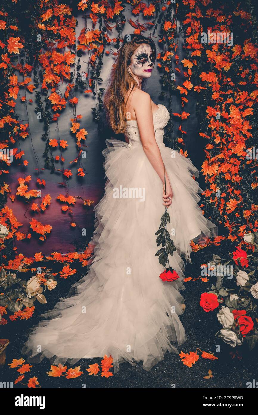 Femme avec maquillage fantôme et robe de mariage tenant une moitié rose  Photo Stock - Alamy