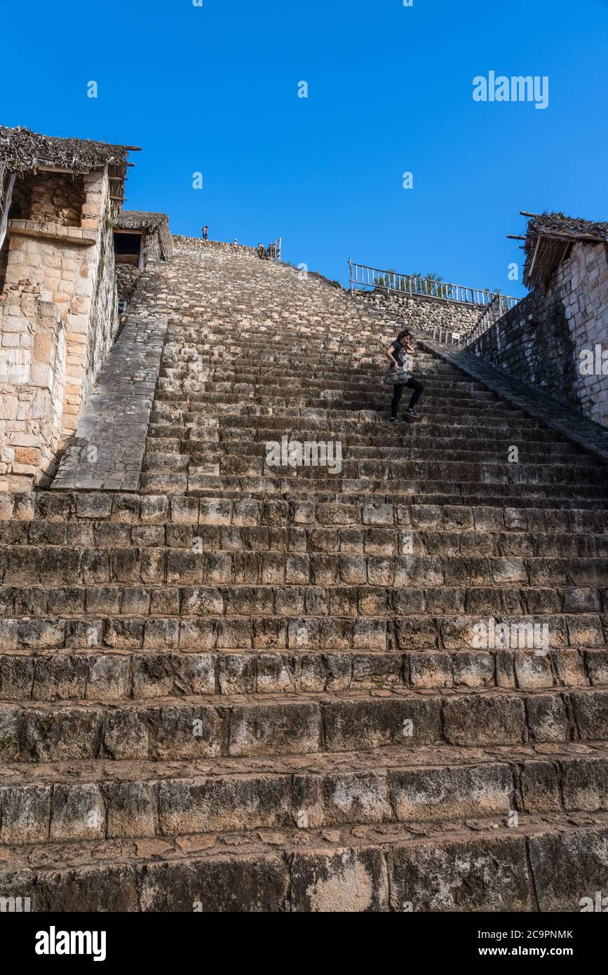 Un touriste descend l'escalier très raide sur l'Acropole dans les ruines préhispaniques de la ville maya d'Ek Balam à Yucatan, Mexique. Banque D'Images