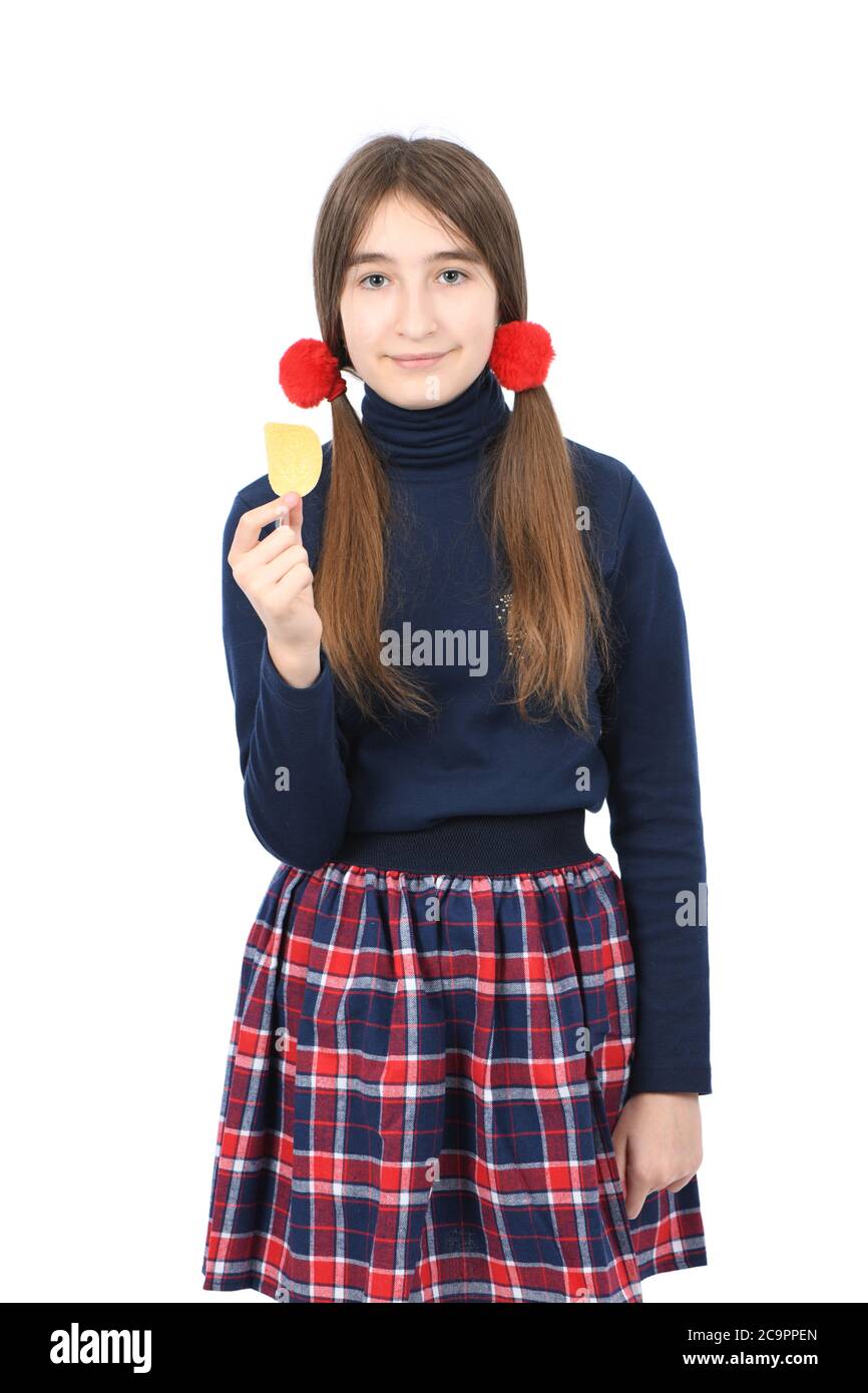 Portrait d'une jeune fille préadolescente tenant des chips de pomme de terre. Isolé sur fond blanc. Photo haute résolution. Profondeur de champ complète. Banque D'Images