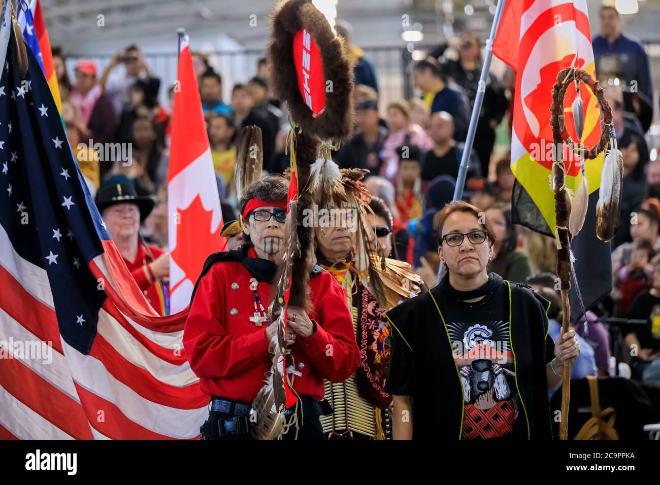 San Francisco, États-Unis - février 08 2020 : les natifs américains vêtus de tenues traditionnelles portent un personnel d'aigle traditionnel et des drapeaux à l'entrée officielle de Powwow Banque D'Images