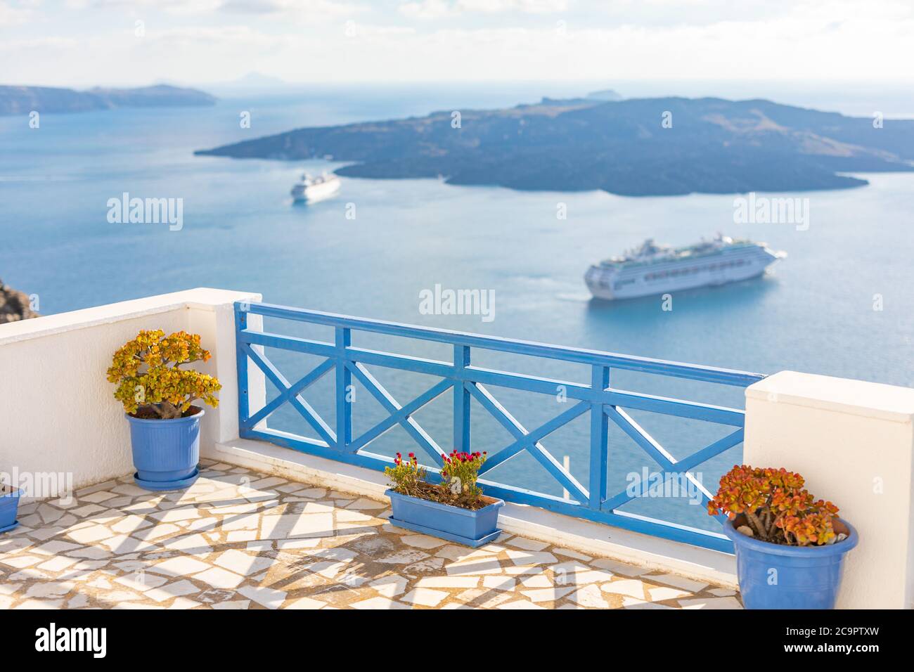Vue paisible à Santorin, Grèce avec architecture blanche et fleurs, bateaux de croisière, ambiance méditerranéenne d'été, vacances et fond de voyage. Banque D'Images