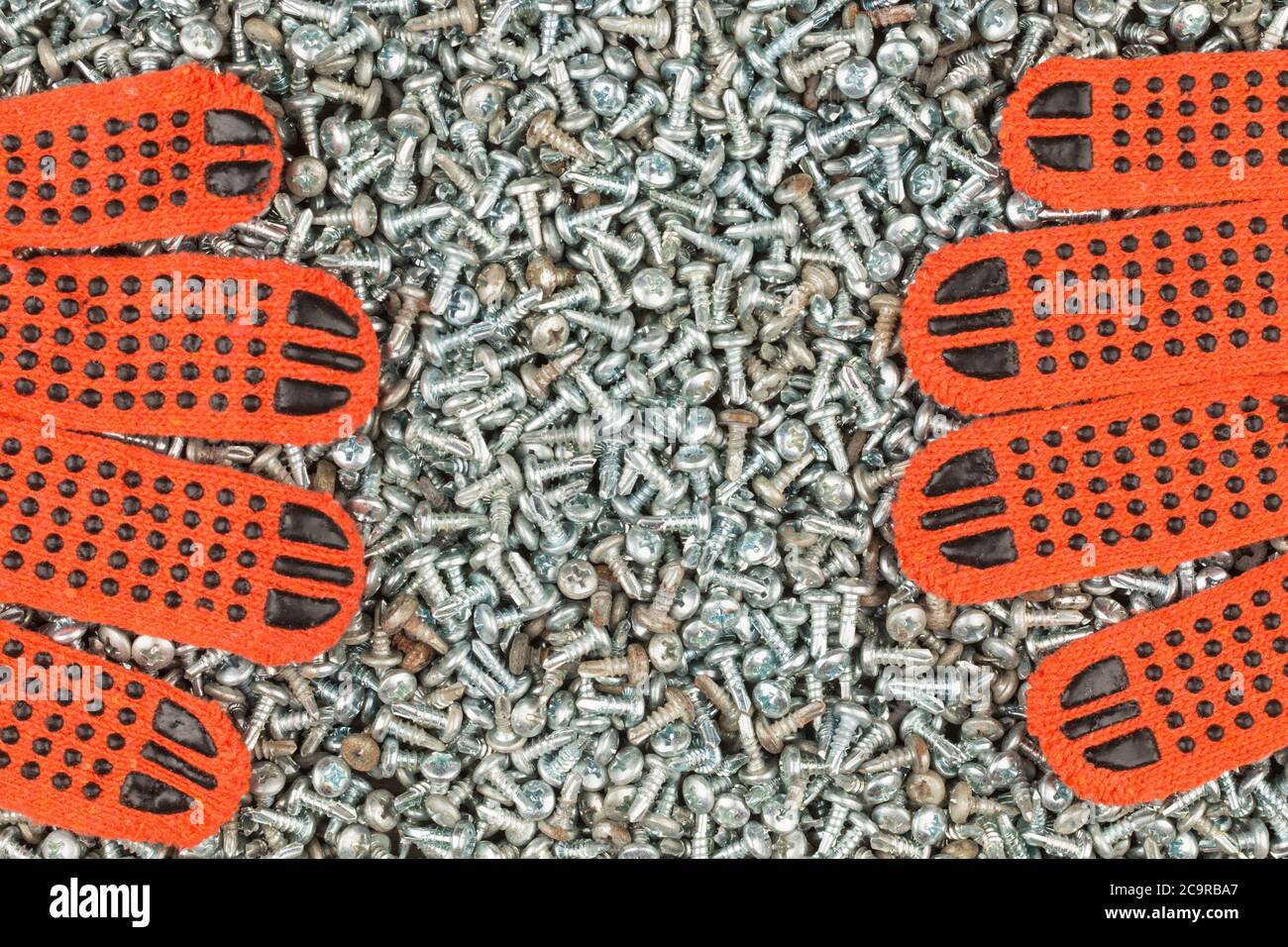 Les gants de travail reposent sur des vis galvanisées. Vue de dessus Banque D'Images