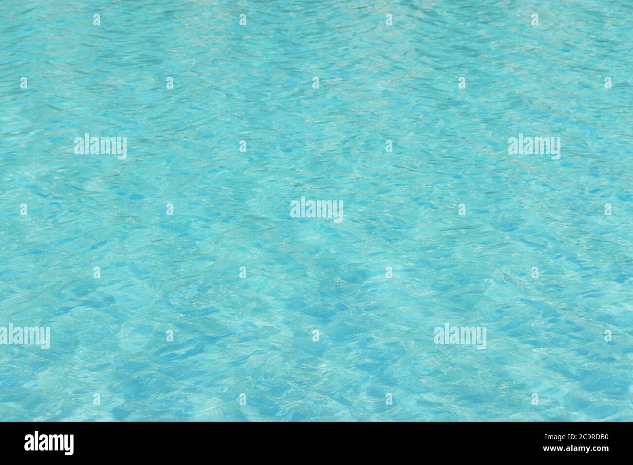 La texture bleue de l'eau de la piscine reflète le soleil rippé Banque D'Images