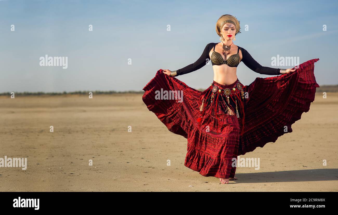 la fille de la danseuse en robe longue rouge tient une robe à la main avec  un maquillage et un art du visage dans le style tribal américain Photo  Stock - Alamy