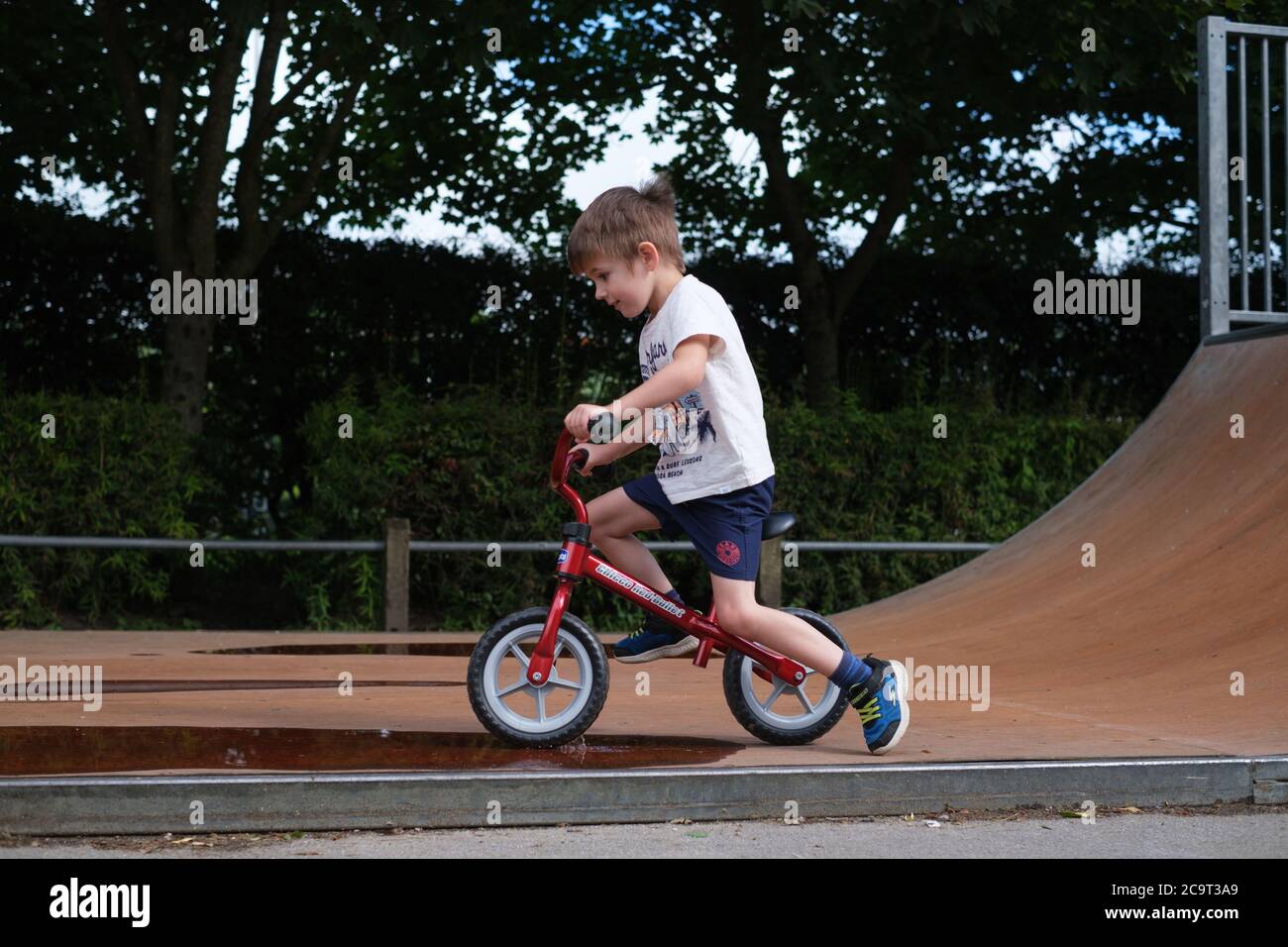 Garçon de quatre ans jouant sur un vélo Balance dans un parc à roulettes d'Ilkley West Yorkshire Banque D'Images