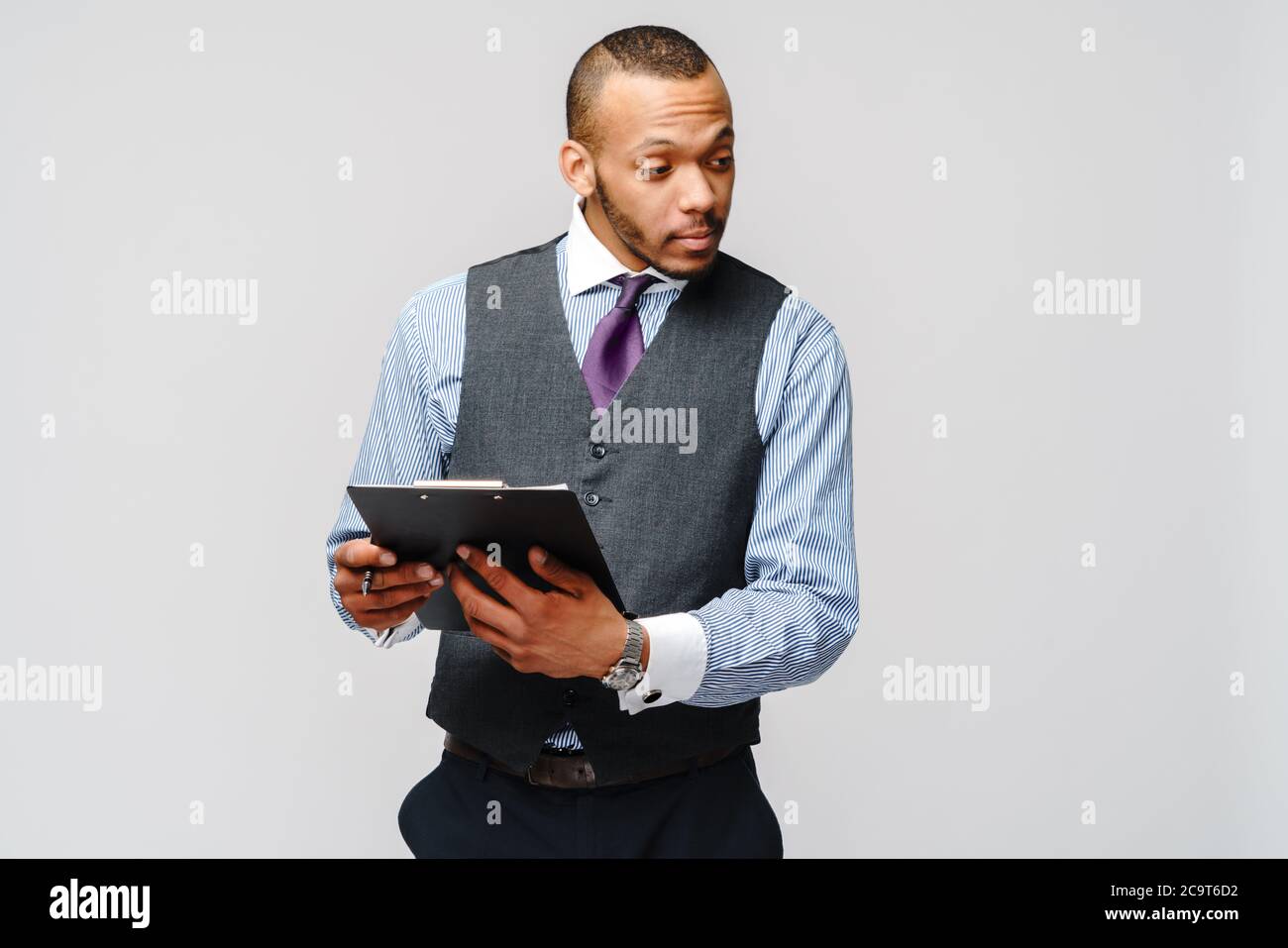 un jeune africain américain tenant une tablette de table et un stylo Banque D'Images