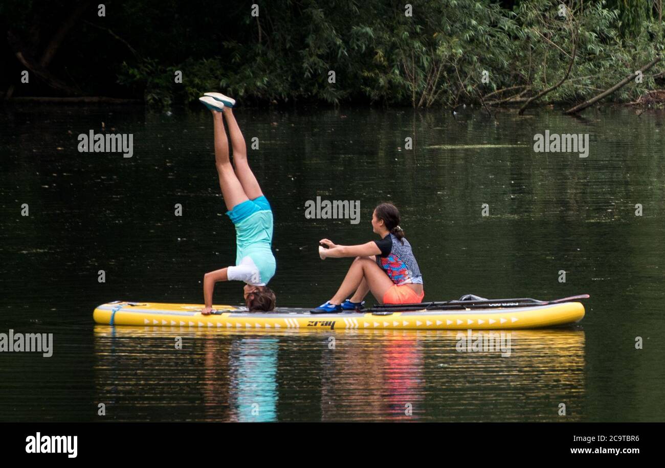 Hambourg, Allemagne. 02 août 2020. Une femme se tient debout sur un stand-up paddleboard (SUP) sur un canal de l'Alster. Credit: Daniel Bockwoldt/dpa/Alay Live News Banque D'Images