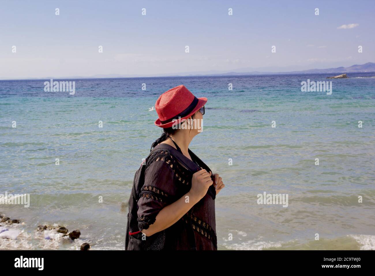 belle jeune femme dans un chapeau rouge sur la plage Banque D'Images