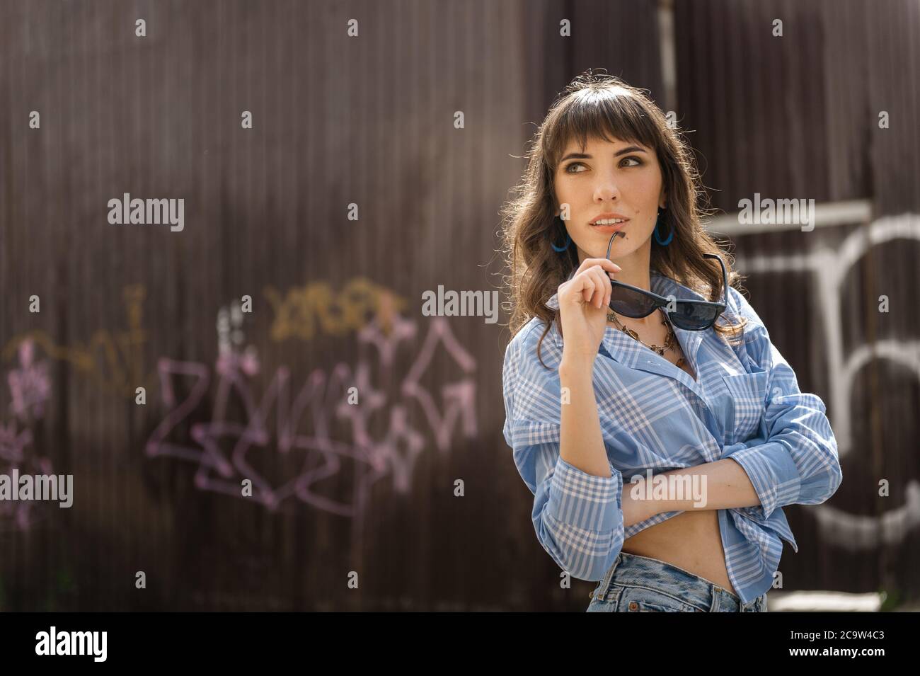 fille dans une chemise bleue contre le mur de graffiti dans la ville Banque D'Images