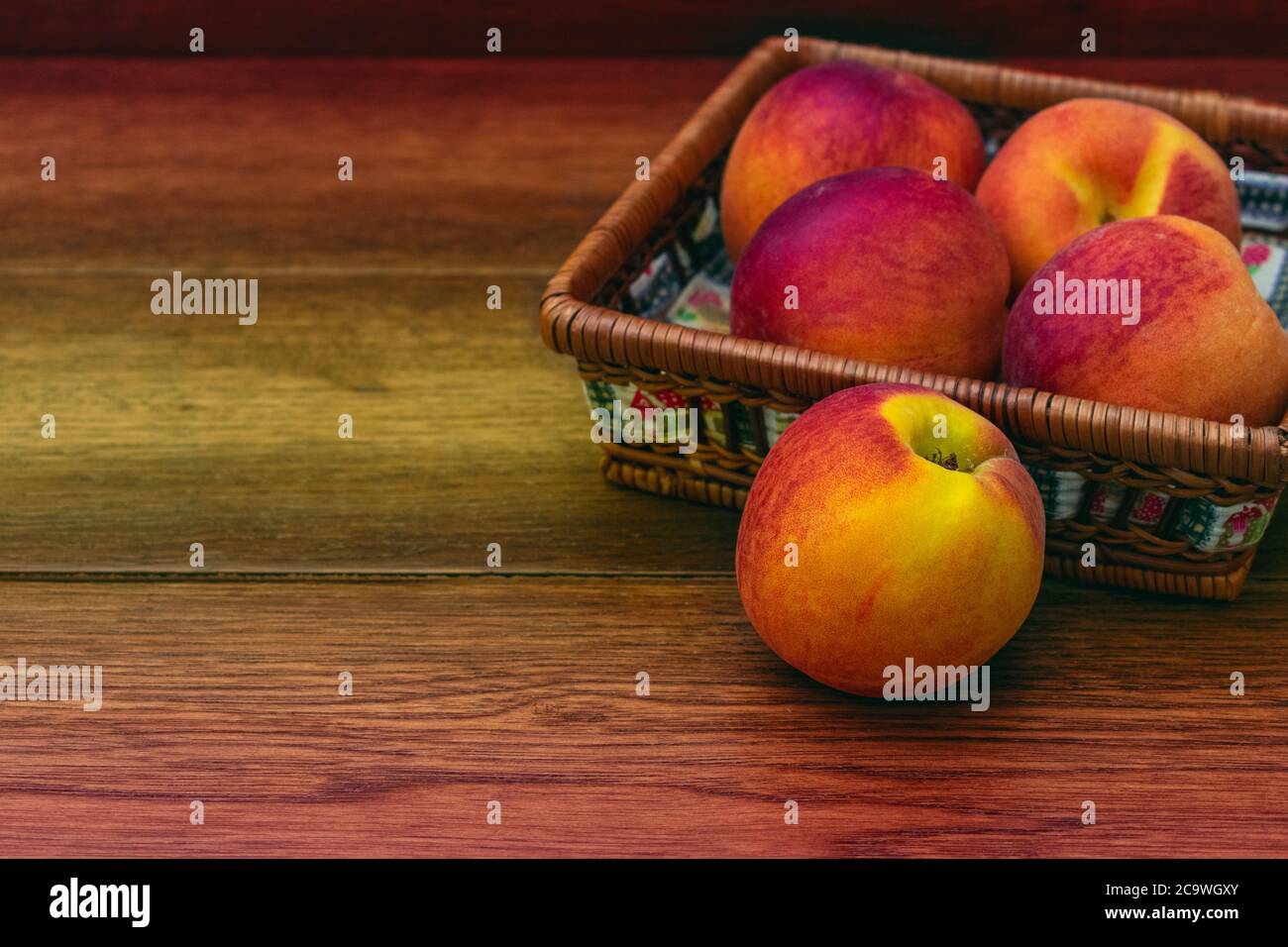 Panier de pêches sur fond en bois avec espace de copie Banque D'Images