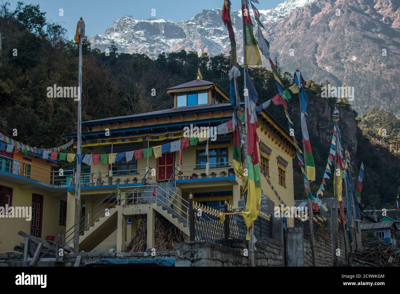 Monastère bouddhiste jaune avec drapeaux de prière bouddhiste, sous les montagnes himalayens le long du circuit Annapurna Banque D'Images