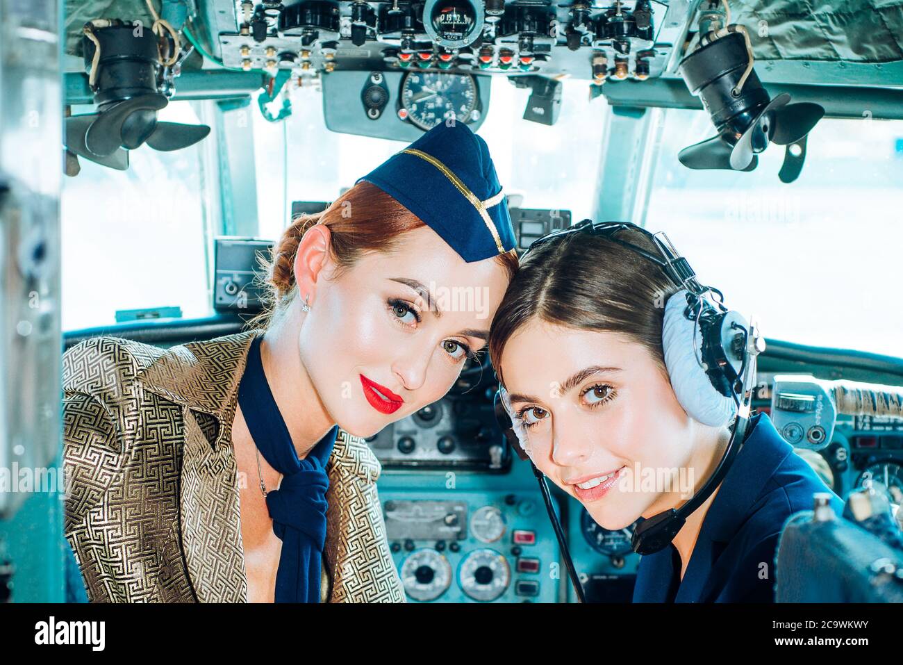 Portrait de deux femmes pilotes souriantes. Belle jeune femme souriante pilote assis dans la cabine d'un avion moderne. Hôtesse et instructeur de vol dans un Banque D'Images