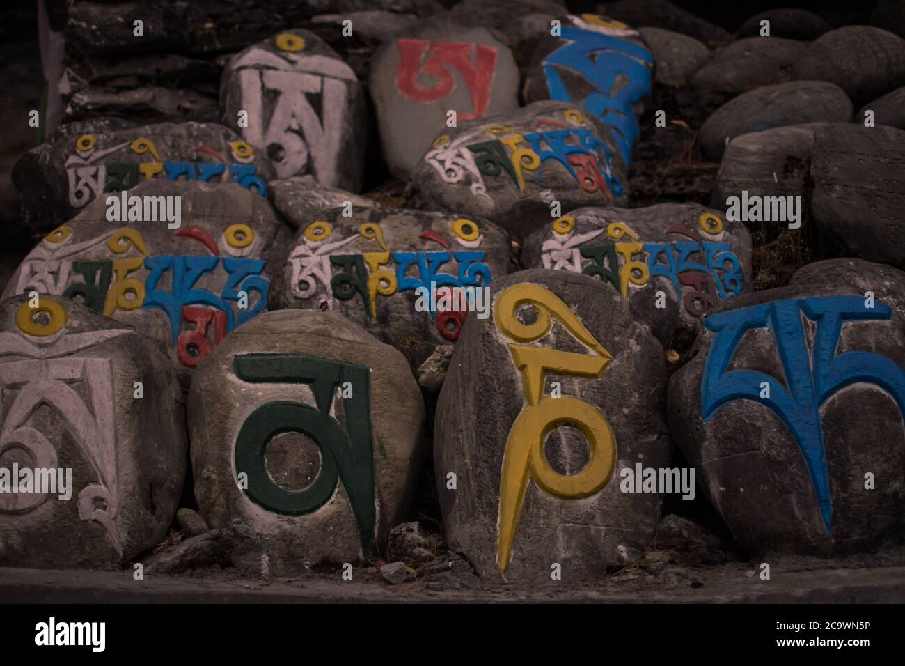 Inscriptions religieuses colorées en pierres, village de montagne de Chame, trekking circuit Annapurna, Népal Banque D'Images