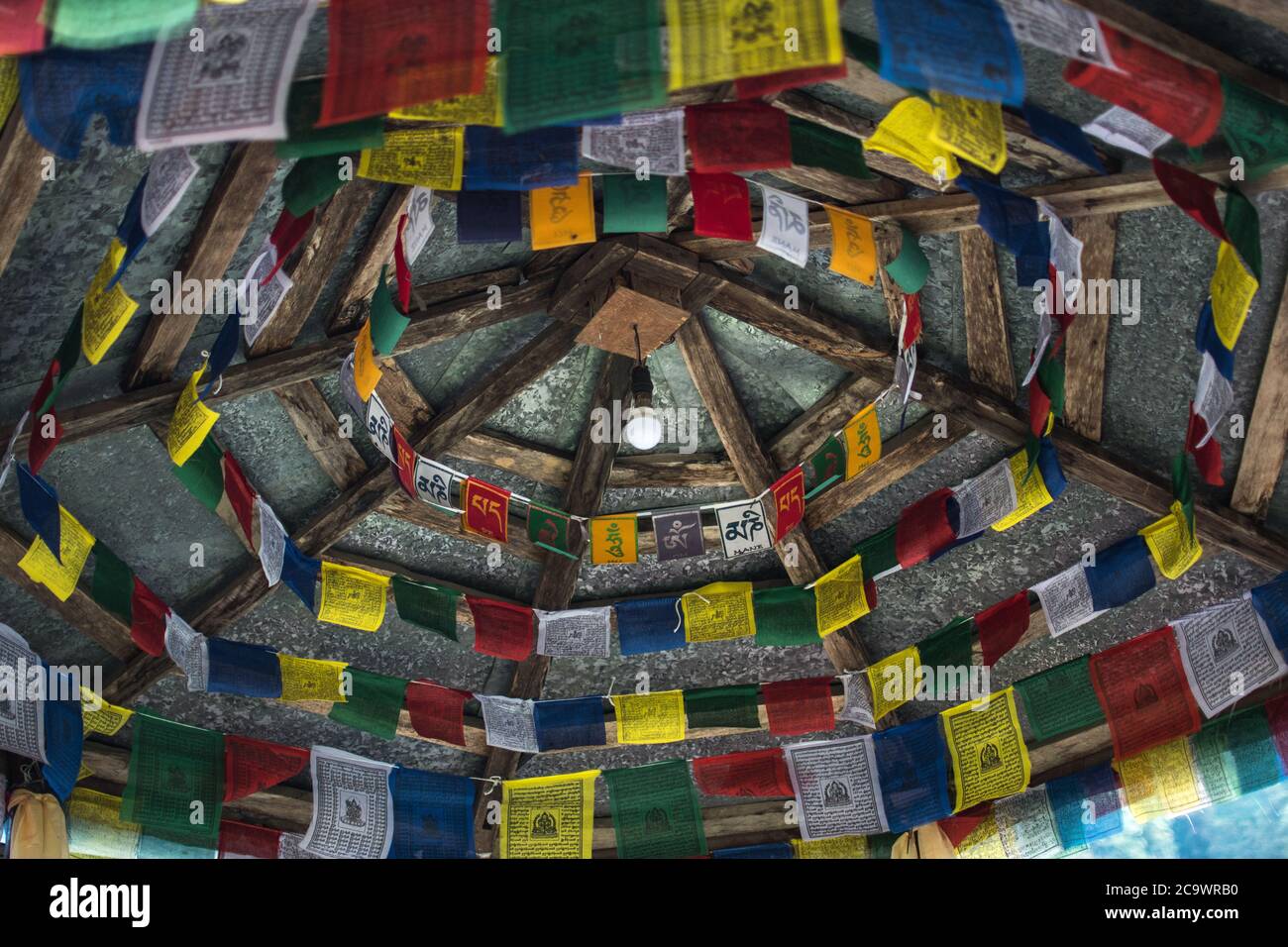 Drapeaux bouddhistes colorés et lumineux suspendus depuis un plafond dans les montagnes du Népal Banque D'Images