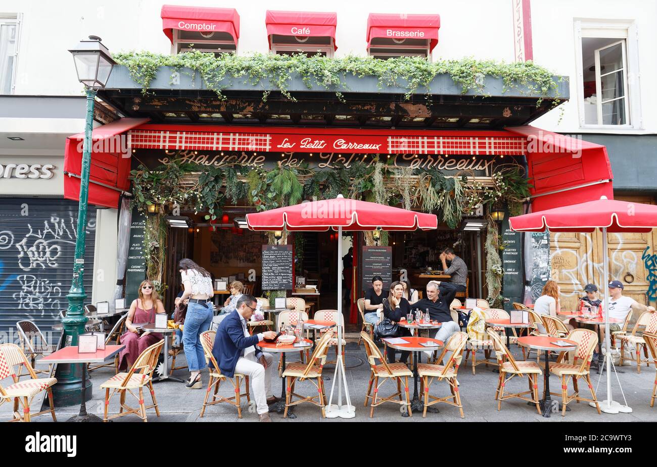 Personnes assises dans un café traditionnel français les petits Carreaux, rue Montorgueil à Paris, France. Banque D'Images