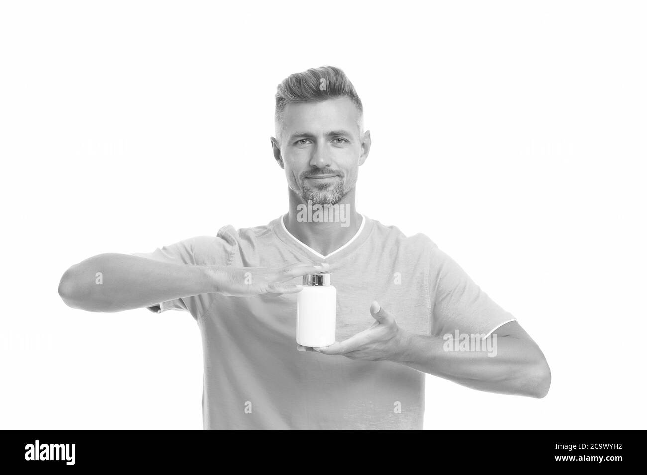 Vital pour la santé osseuse. Vitamines et minéraux. Essentiel pour le système immunitaire. Effets secondaires. Concept de médicaments. Additifs alimentaires vitamines pour la santé masculine. Complexe de vitamines. Beau homme présentant le produit. Banque D'Images