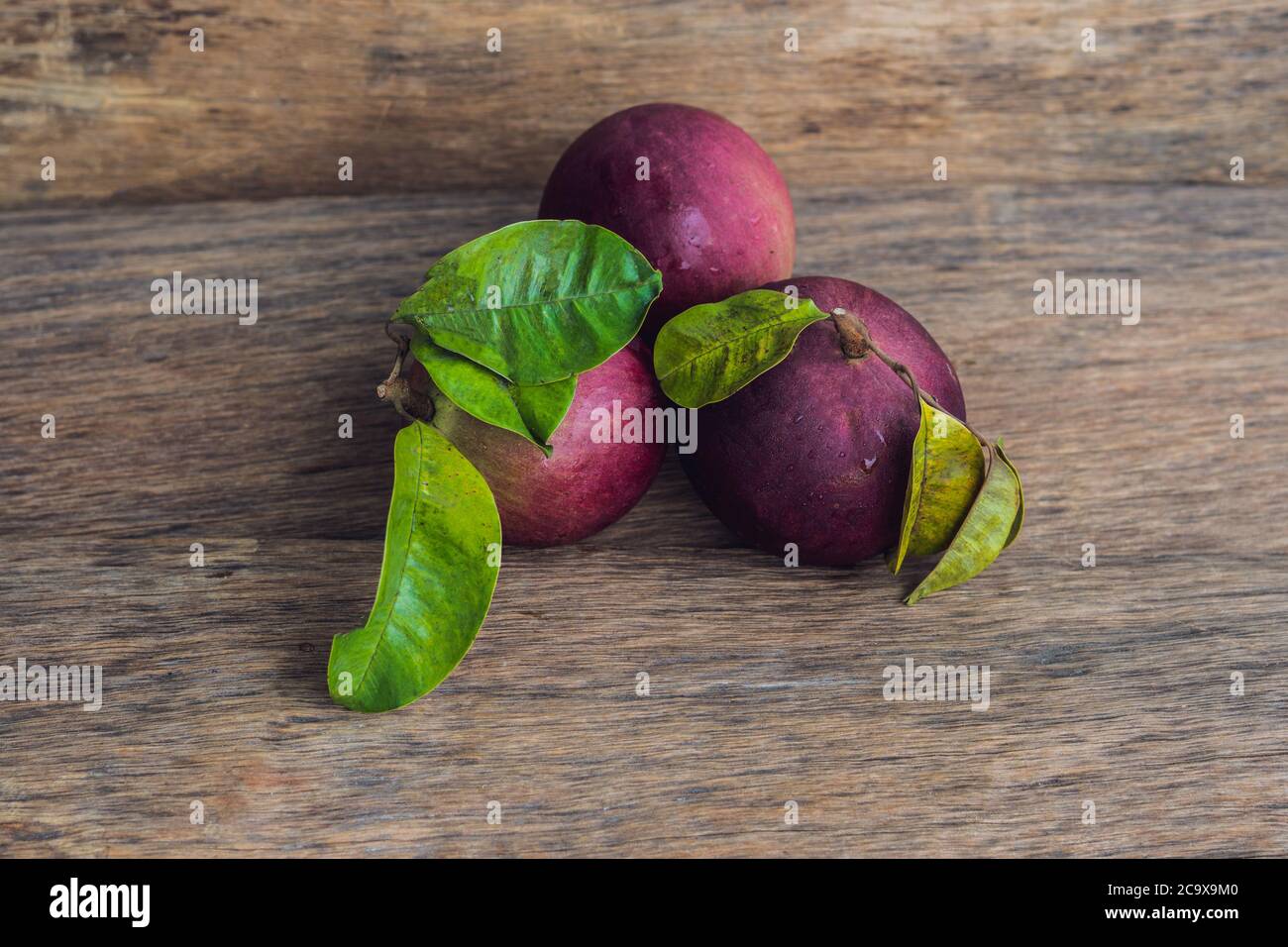 Fruits frais de Chrysophyllum cainito sur fond de bois Banque D'Images