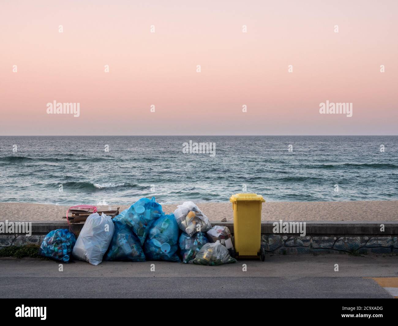 Gangneung, province de Gangwon, Corée du Sud - UN tas de déchets et une poubelle sur la plage de Sacheon Beach. Ciel de coucher de soleil. Crépuscule. Un tas de déchets et un panier à déchets. Banque D'Images