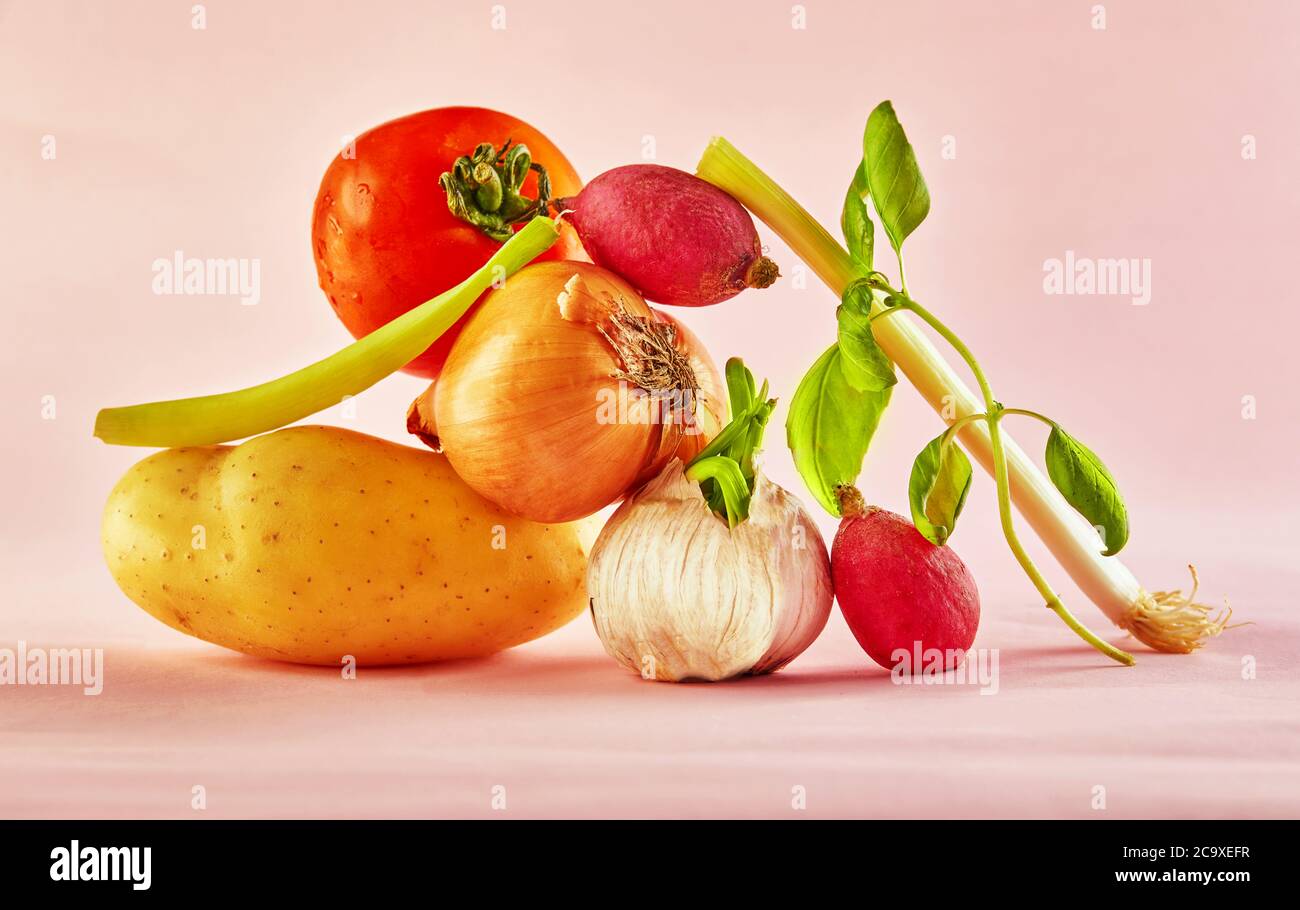 Une composition gastronomique avec des légumes colorés sur fond rose, pour une gastronomie amusante et une recette végétarienne. Équilibre flottant nourriture balanc Banque D'Images