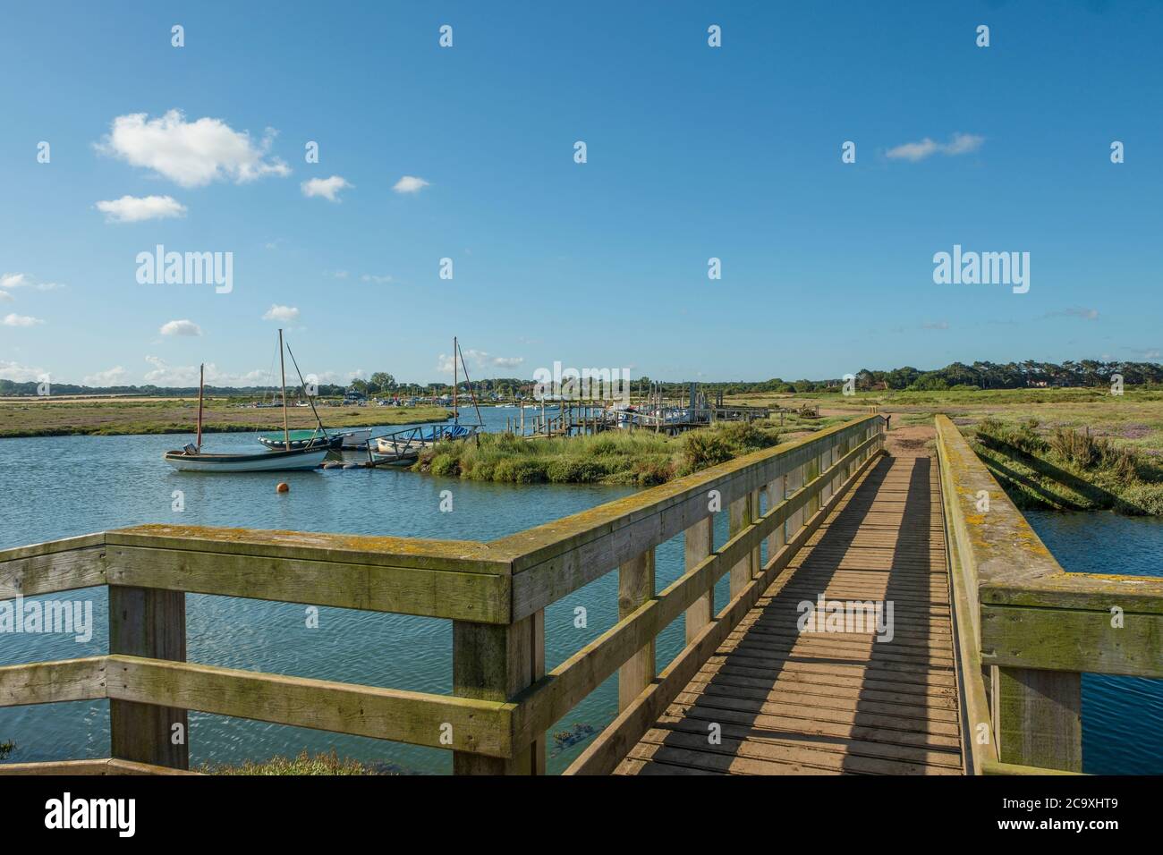 Un pont au-dessus d'un ruisseau dans le marais salin de Norfolk. Banque D'Images
