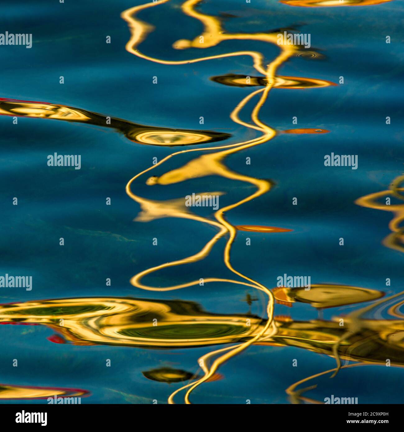 Reflets de la lumière du soleil créant des motifs abstraits sur la surface de l'eau en fin d'après-midi Banque D'Images