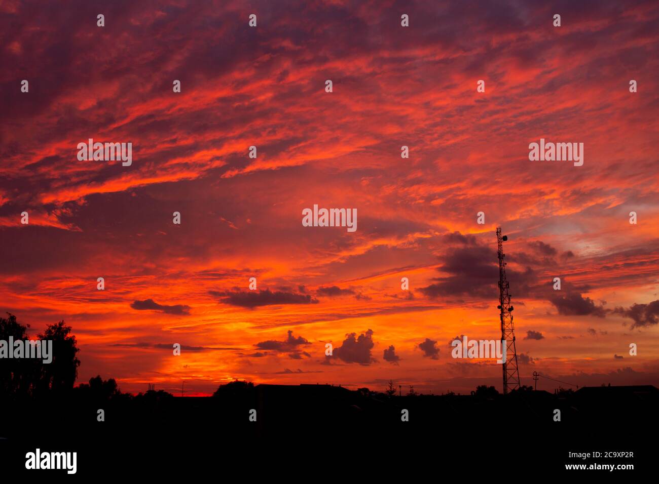 Tour de communication mobile au coucher du soleil avec un ciel rouge sur fond. Sans fil, 5G, concept mobile Banque D'Images