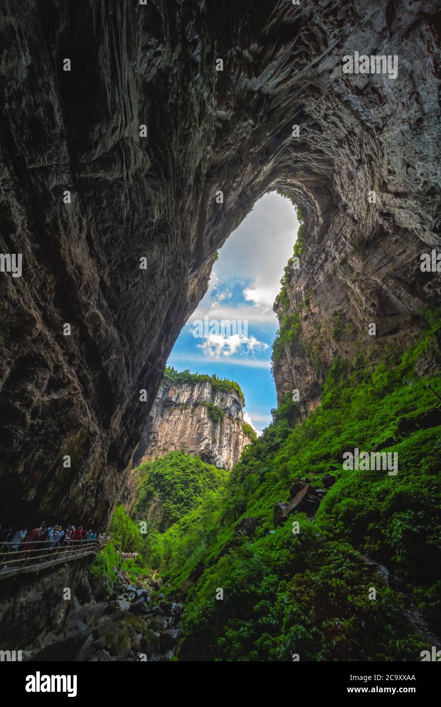 Wulong, Chine - août 2019 : foules de touristes marchant sur un chemin étroit vers la fissure naturelle de l'arche rocheuse dans un canyon parmi le paysage karstique de Banque D'Images