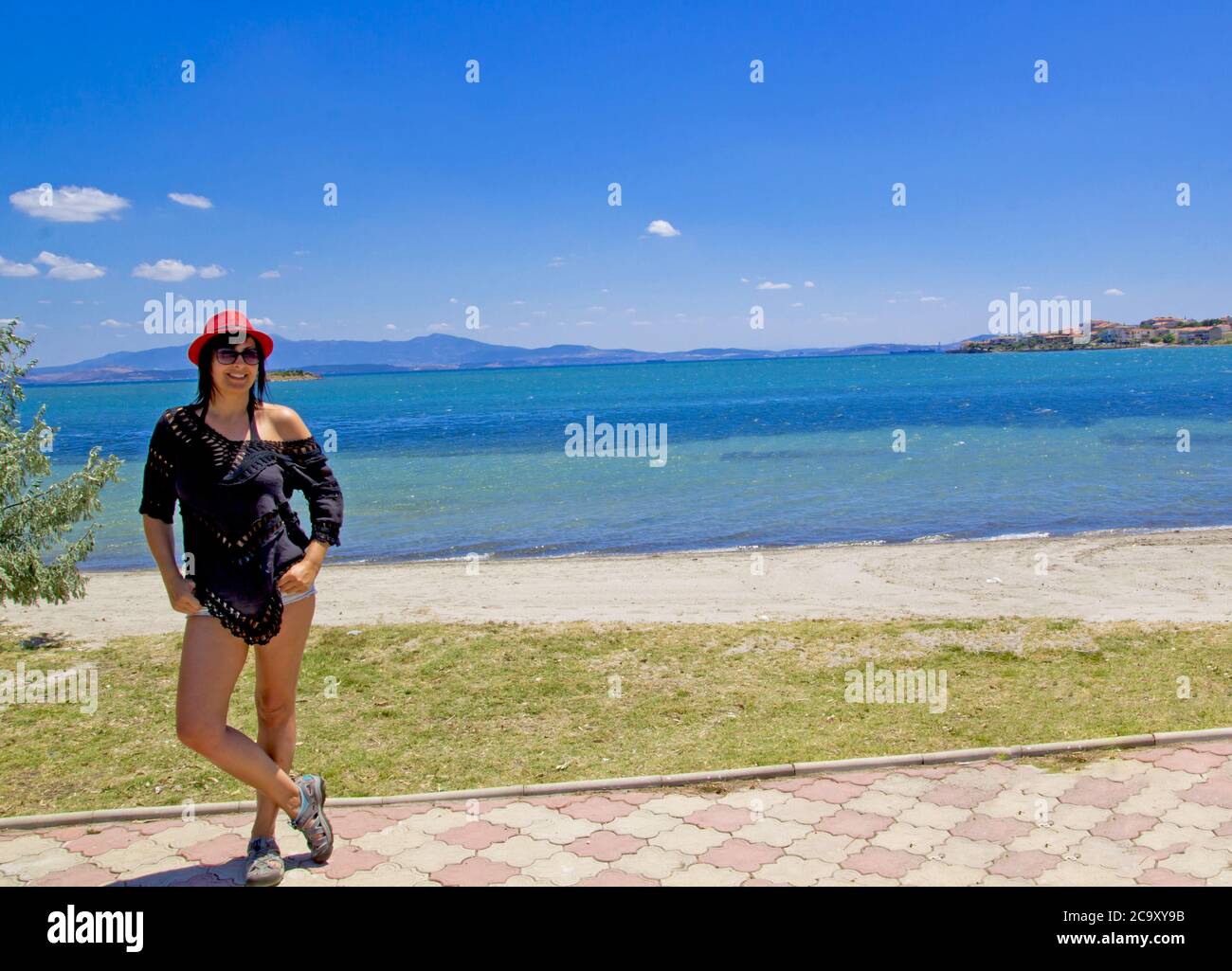 belle jeune femme dans un chapeau rouge sur la plage Banque D'Images