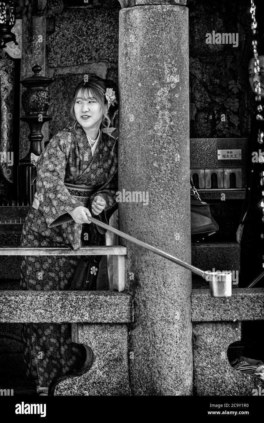 Jeune femme en vêtement kimono qui boit de la fontaine d'eau sainte de la cascade d'Otowa-no-Taki dans les locaux du temple de Kiyomizu-dera, Kyoto, Japon Banque D'Images