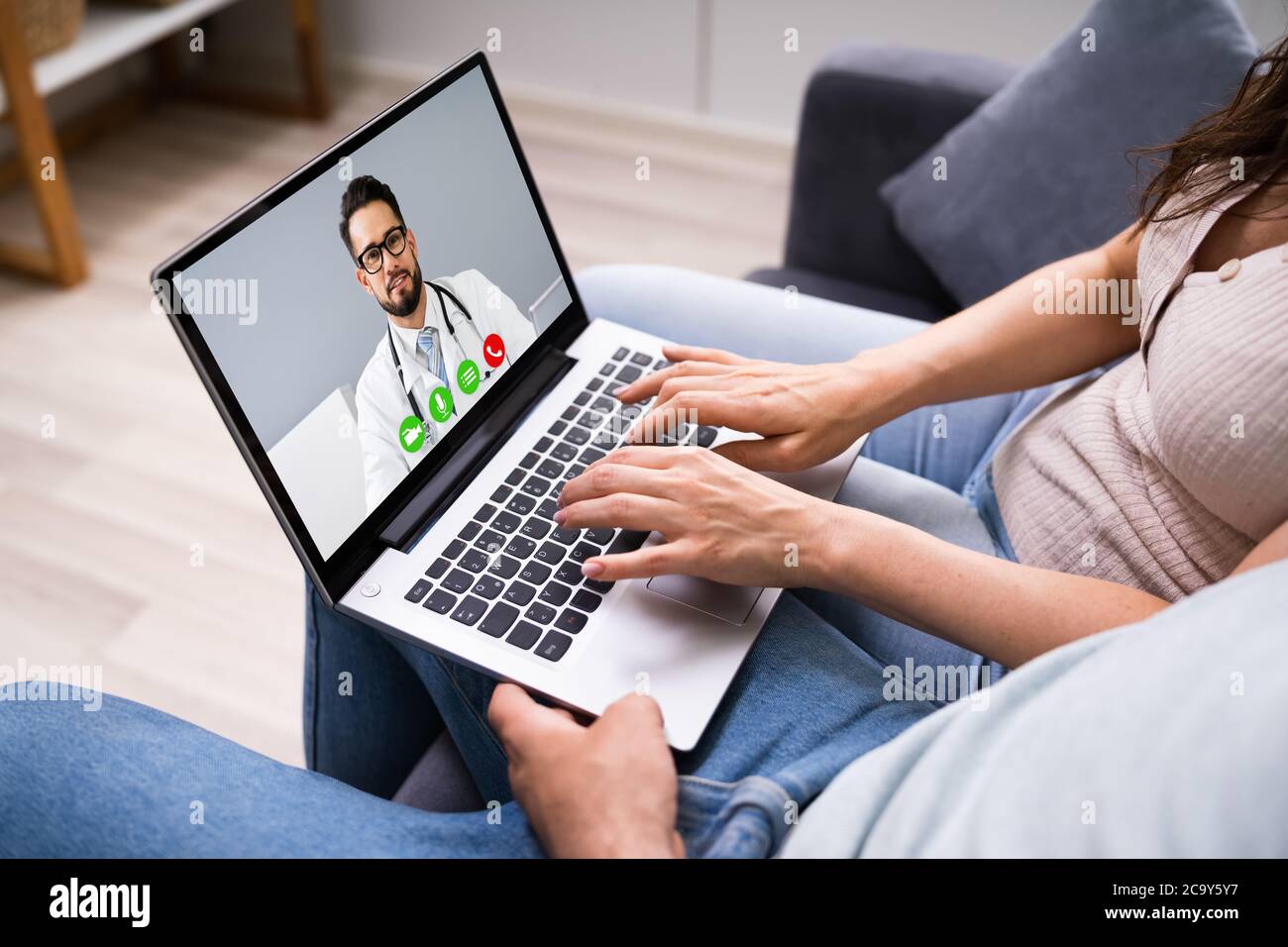 Couple enceinte en appel de vidéoconférence en ligne avec le médecin Banque D'Images