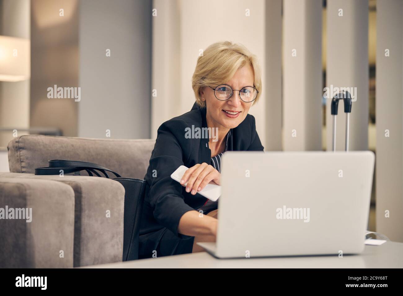 Belle femme utilisant un ordinateur portable avant un voyage d'affaires Banque D'Images