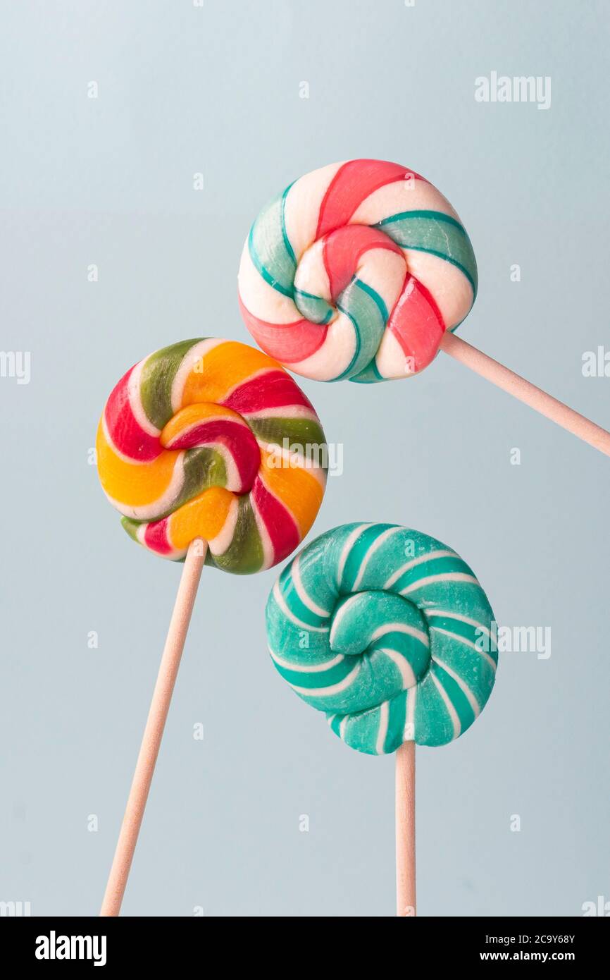 focalisé sélectif, sucettes rondes au caramel, avec différentes saveurs, à base de sucre. sur fond bleu Banque D'Images