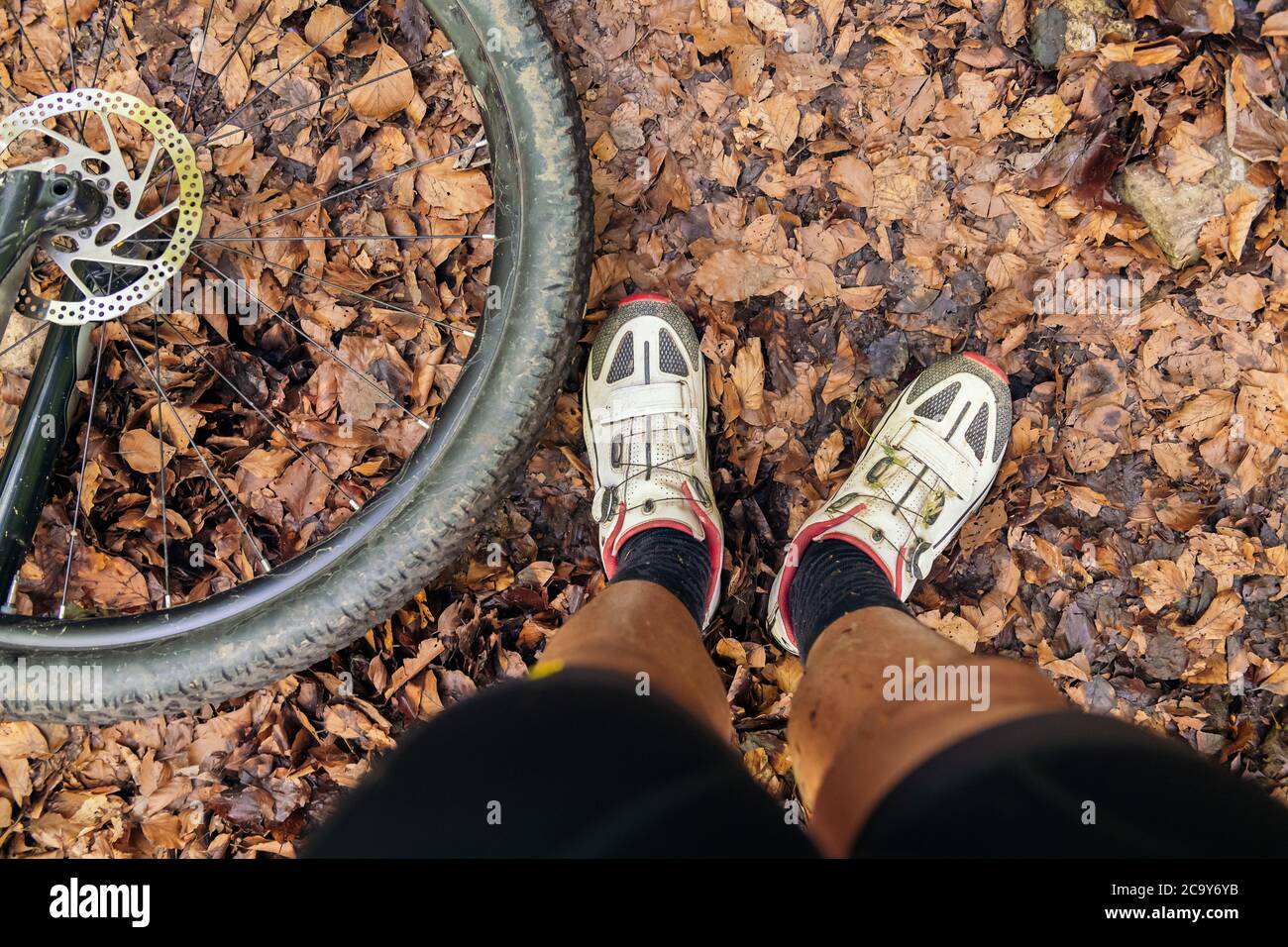 détail d'un cycliste des jambes sales et la roue de son vtt, concept d'effort dans le sport et un mode de vie sain dans la nature, espace de copie pour le texte Banque D'Images