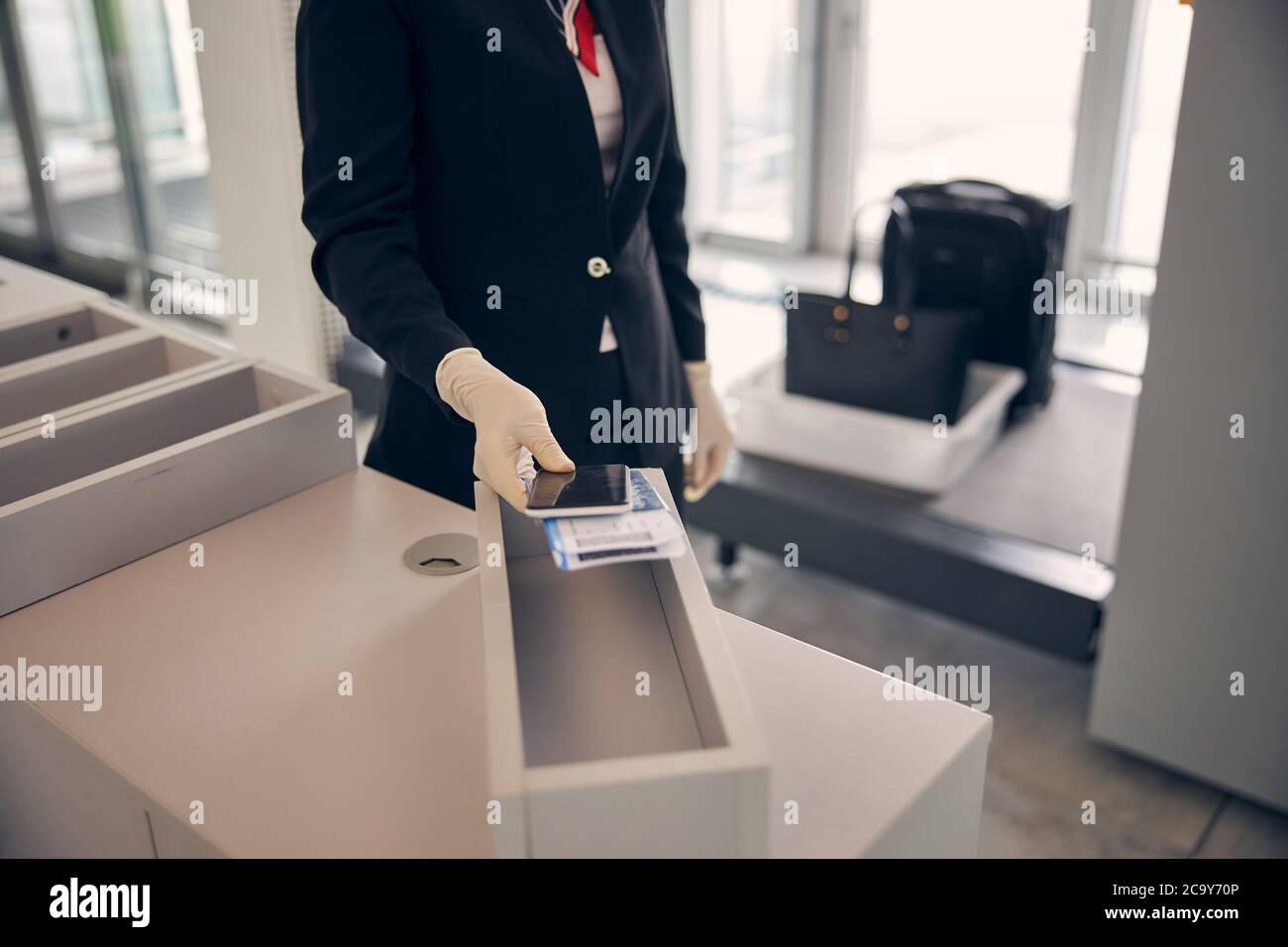 Femme d'affaires mettant un smartphone et un billet d'avion dans une boîte Banque D'Images