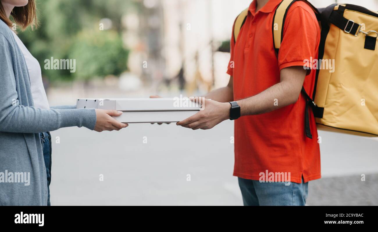 Plats à emporter et livraison. Livreur avec sac à dos, montres  intelligentes donner des boîtes avec pizza pour fille dans décontracté  Photo Stock - Alamy