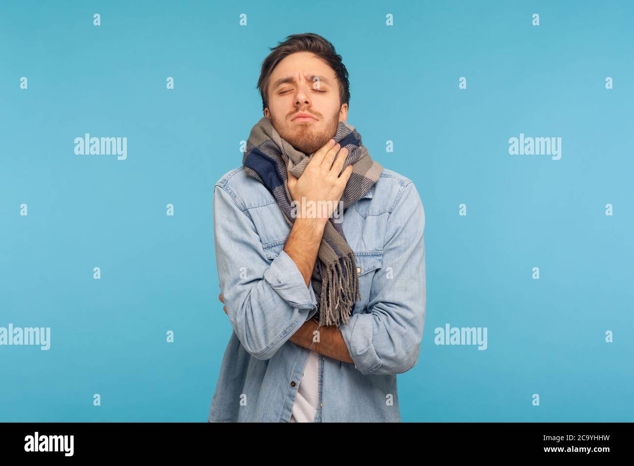 Portrait d'un homme malade de la grippe malsain debout enveloppé dans un foulard chaud frississant du froid, se sentant mal souffrir de la fièvre, les symptômes de la grippe saisonnière. Dans Banque D'Images