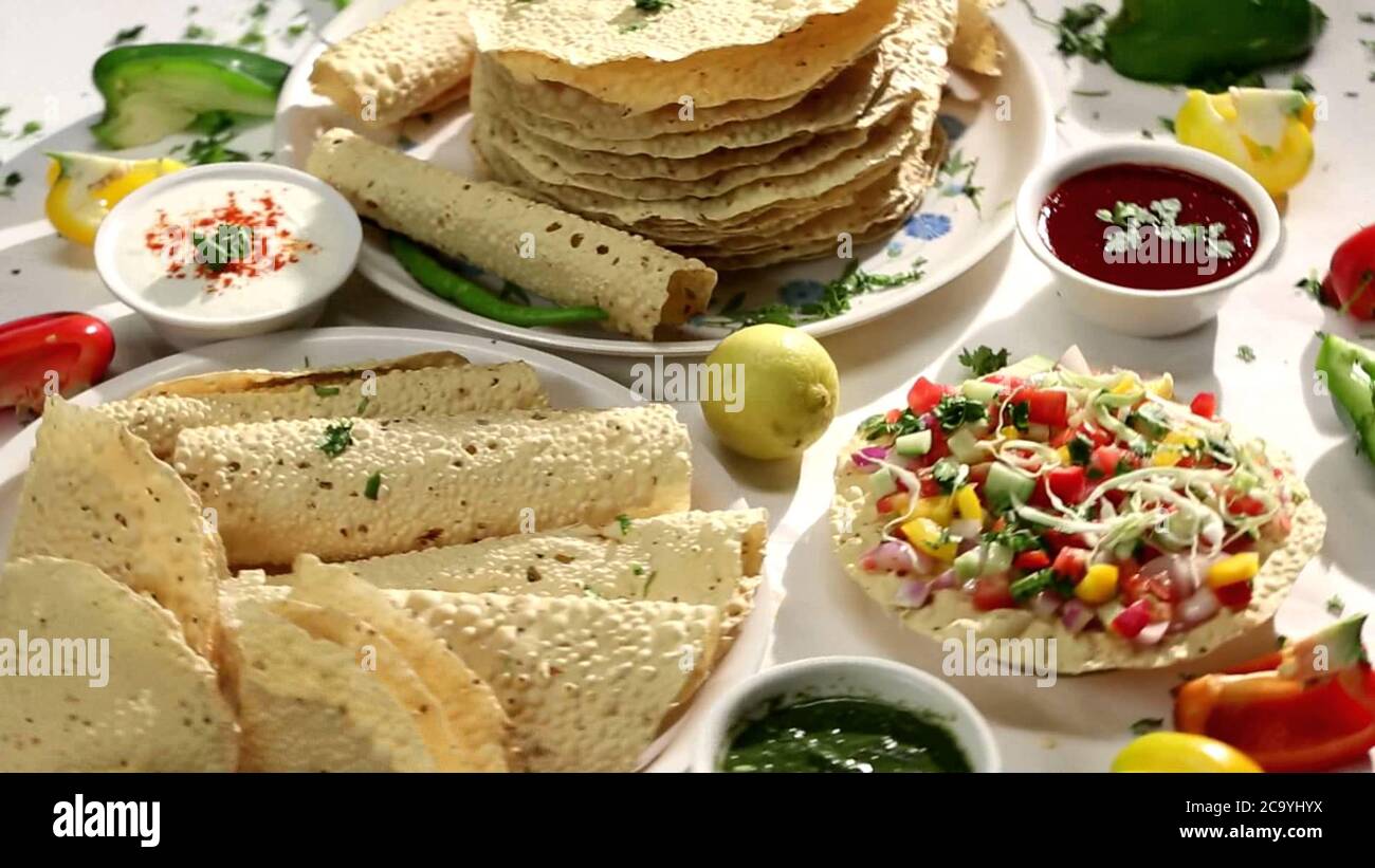 En-cas indiens, craquelins Mung/Urad dal frits ou rôtis ou papayes, accompagnement au déjeuner et au dîner. Servi dans un panier de canne/assiette Banque D'Images