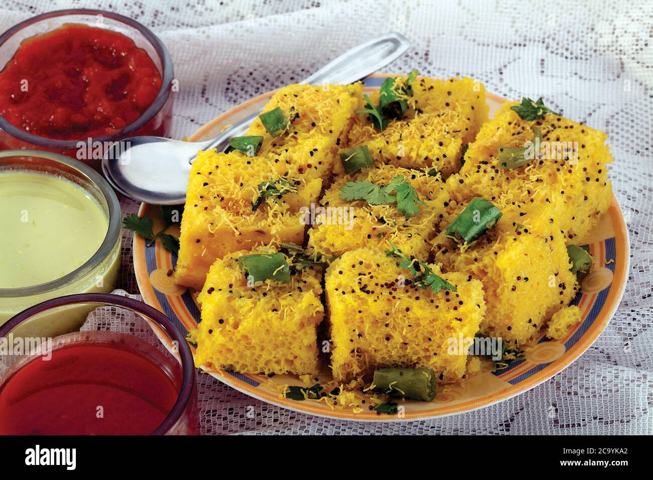 Plat indien/gujarati populaire cuisine traditionnelle de rue Sev Khhaman Dhokla servi avec Chutney et Chili. Attention sélective - image Banque D'Images