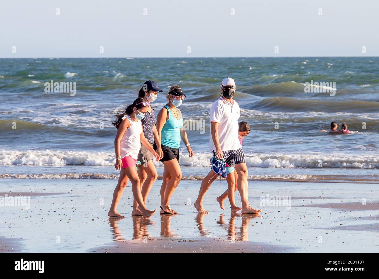 Punta Umbria, Huelva, Espagne - 2 août 2020 : une famille marchant sur la plage avec des masques protecteurs ou médicaux. Nouvelle normale en Espagne avec social Banque D'Images