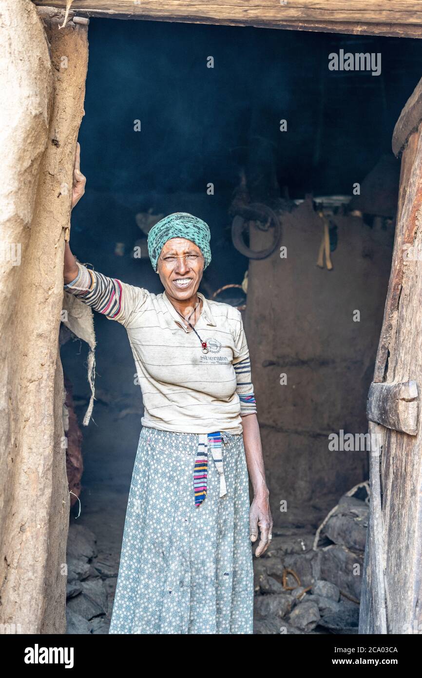 Portait de femme debout à l'entrée de sa cabane, province de Wollo, région d'Amhara, Éthiopie, Afrique Banque D'Images