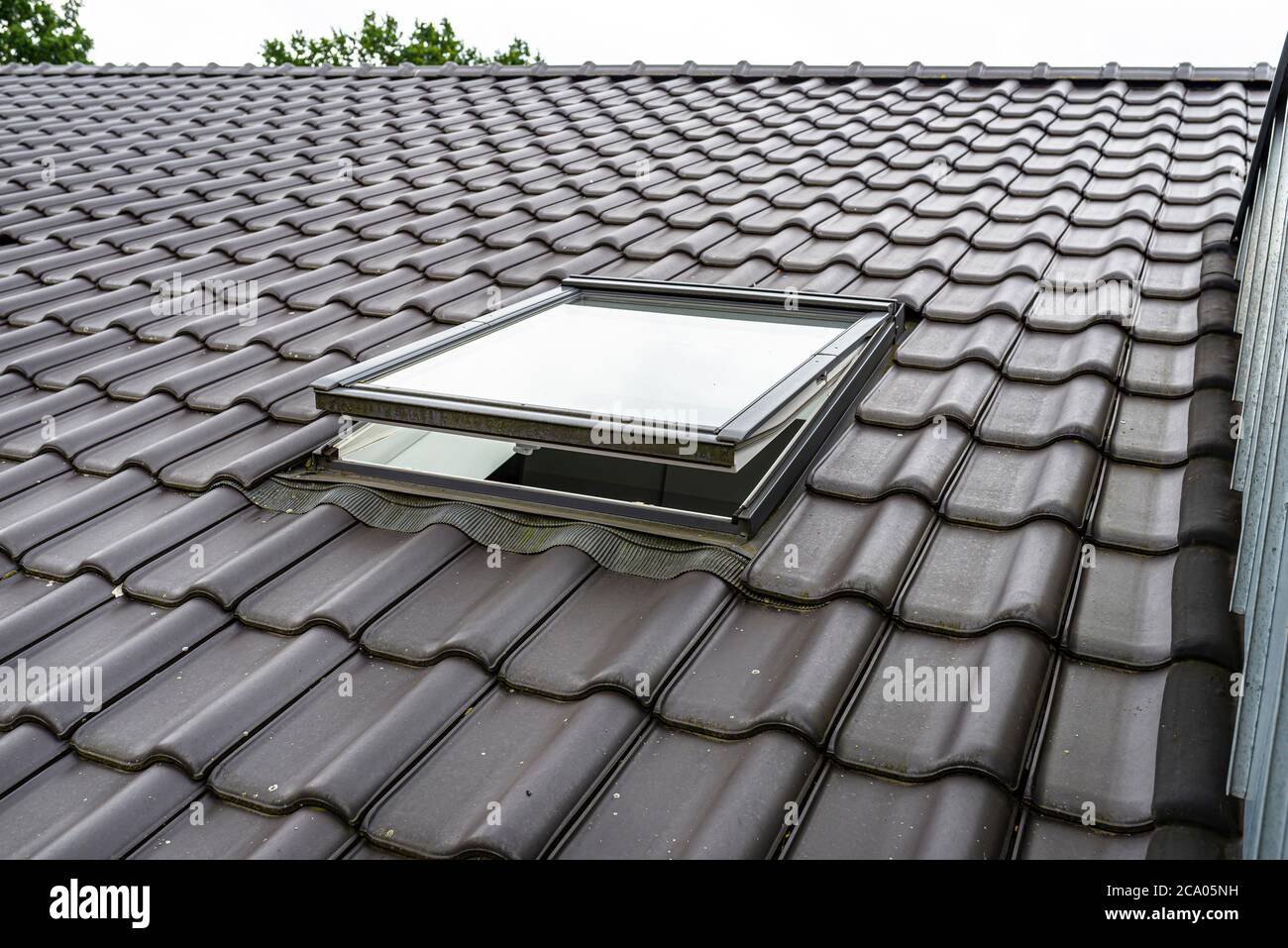 Une fenêtre de toit ouverte dans le grenier, carreaux de céramique  anthracite visibles Photo Stock - Alamy